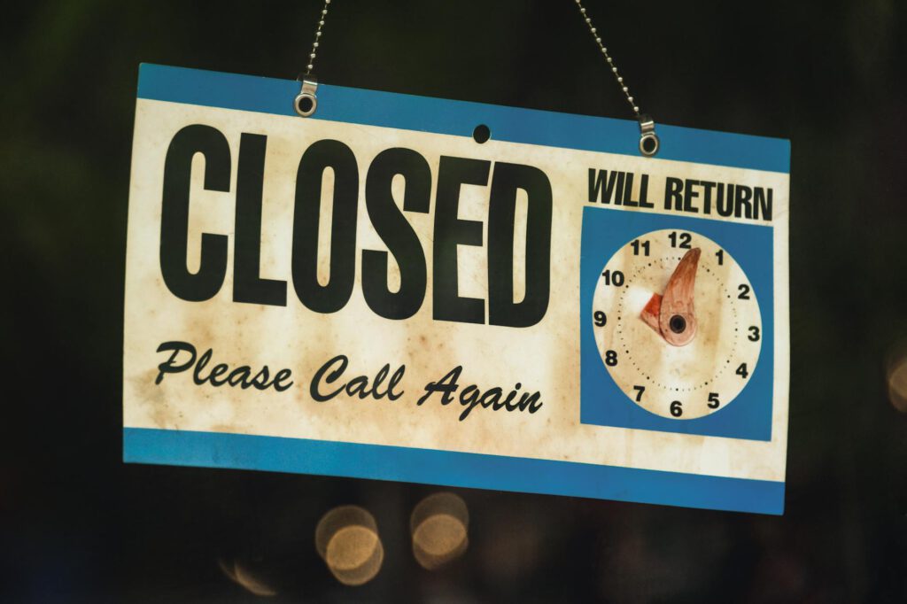 A vintage closed sign with adjustable clock in Estes Park, Colorado at night.