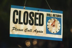 A vintage closed sign with adjustable clock in Estes Park, Colorado at night.